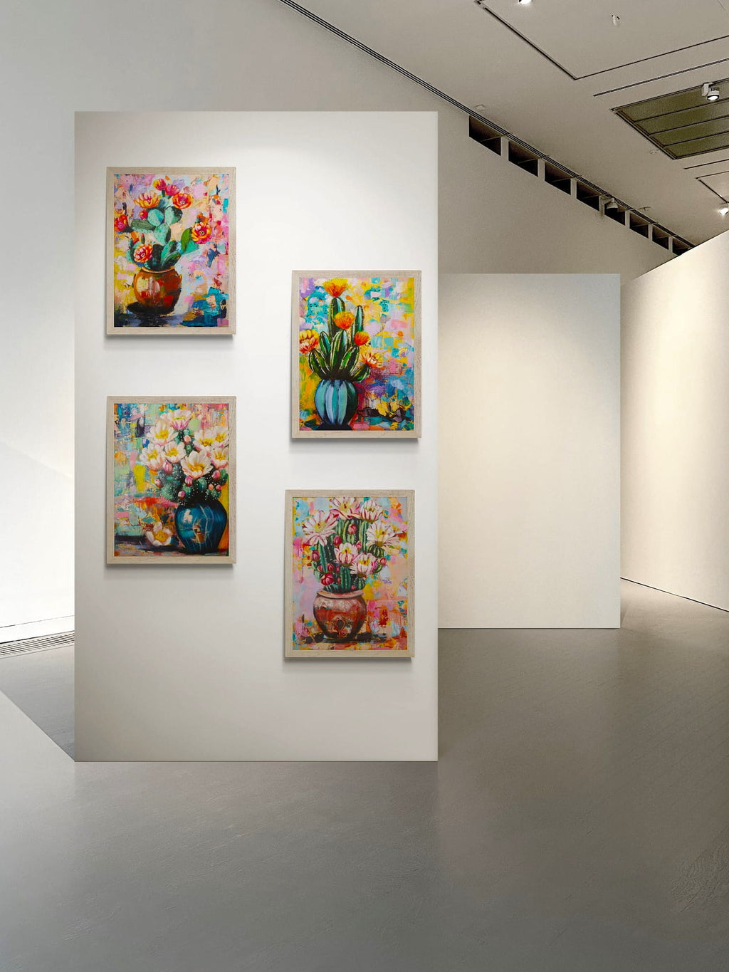 Four colorful cactus paintings displayed on a white gallery wall.