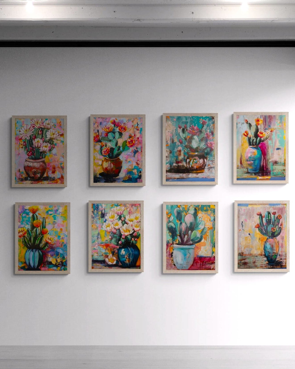 Set of eight colorful floral and cactus paintings on a white wall.