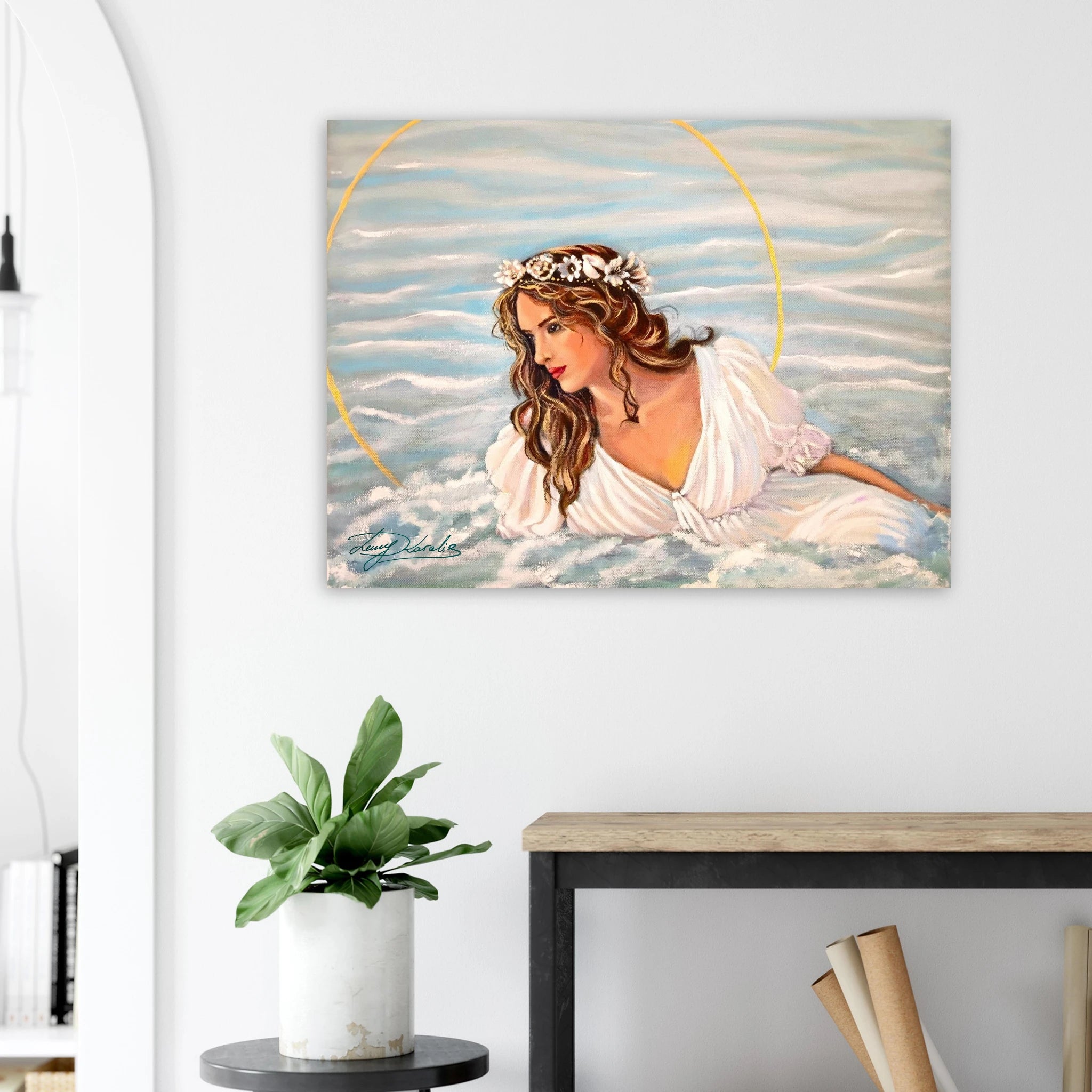 Painting of a woman with a halo on a wall above a desk with a plant and books.