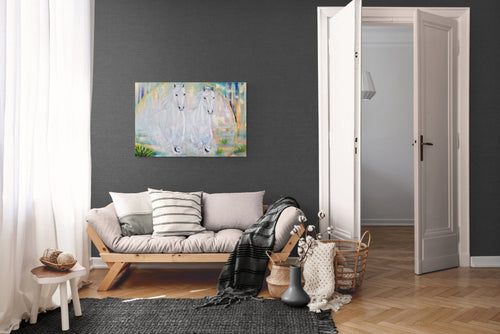 Living room with a gray wall, wooden floor, and a painting of two white horses on abstract background on the wall.
