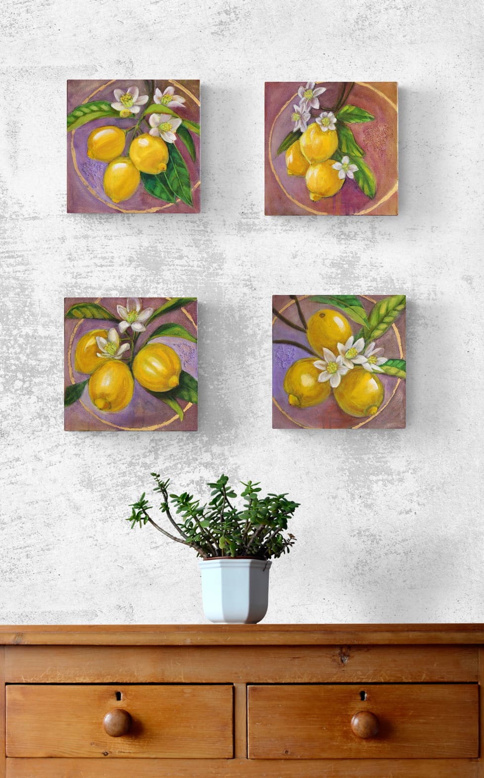 Four square paintings of lemons on a wall above a wooden dresser with a plant.