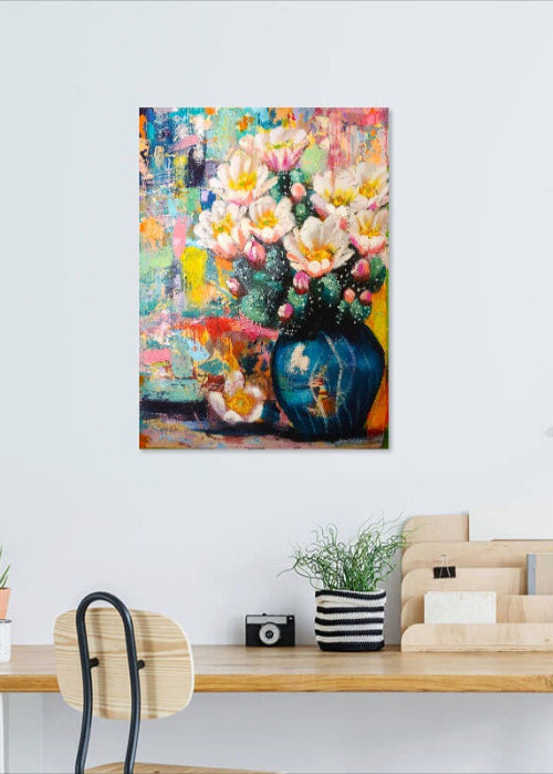 Colorful floral painting on a wall above a desk with office supplies.
